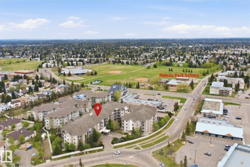Aerial perspective showcasing the multi-story residential building with light-colored siding and dark roofing - 124 10511 42 Avenue, Edmonton, AB 