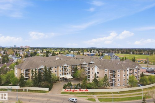 Multi-story condominium complex featuring a neutral-toned exterior, gabled roofs, and multiple private balconies - 124 10511 42 Avenue, Edmonton, AB 