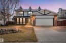 Two-story residence featuring a prominent garage with a concrete driveway, brick accents, and decorative gable detailing - 10673 161 Avenue, Edmonton, AB  - Outdoor With Facade 
