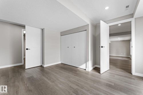 Spacious interior room featuring wood-finish flooring, neutral gray wall tones, and white trim - 10673 161 Avenue, Edmonton, AB - Indoor Photo Showing Other Room