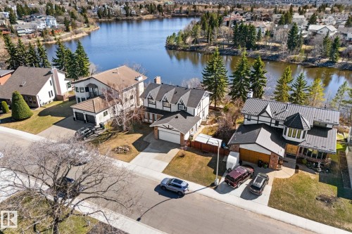 Waterfront property featuring a distinctive Tudor Revival architectural style, multiple gables, and a prominent turret - 10673 161 Avenue, Edmonton, AB - Outdoor With Body Of Water With View