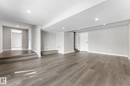 Spacious interior room featuring wood-finish flooring, recessed lighting, neutral wall tones, and white trim throughout - 10673 161 Avenue, Edmonton, AB - Indoor Photo Showing Other Room