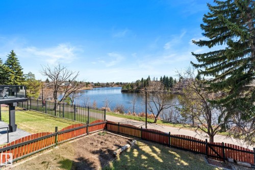Expansive waterfront property featuring a black metal fence bordering a natural body of water - 10673 161 Avenue, Edmonton, AB - Outdoor With Body Of Water
