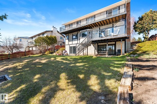 Multi-level rear exterior featuring two expansive balconies with glass railings and a lower-level patio with sliding glass doors - 10673 161 Avenue, Edmonton, AB - Outdoor