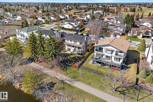 Rear exterior featuring a multi-level deck, bay windows, and mature landscaping - 10673 161 Avenue, Edmonton, AB - Outdoor With Body Of Water With View