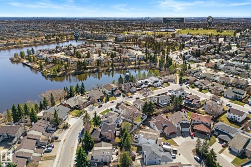 Aerial perspective showcasing a residential neighborhood with a large body of water, extensive green spaces, and mature tree coverage - 10673 161 Avenue, Edmonton, AB - Outdoor With Body Of Water With View