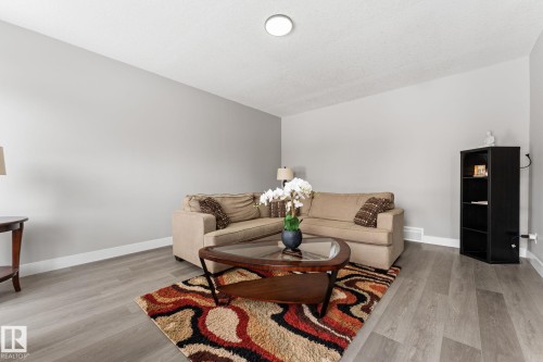 Spacious living area featuring light-toned walls, wood-finish flooring, and white baseboards - 10673 161 Avenue, Edmonton, AB - Indoor Photo Showing Living Room