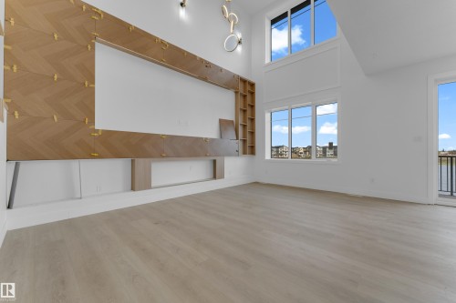 Spacious interior featuring high ceilings, light wood-finish flooring, and white walls - 449 Crystal Creek Link, Leduc, AB - Indoor Photo Showing Other Room