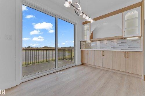 Sliding glass doors opening to a balcony with black metal railings - 449 Crystal Creek Link, Leduc, AB -  Photo Showing Other Room