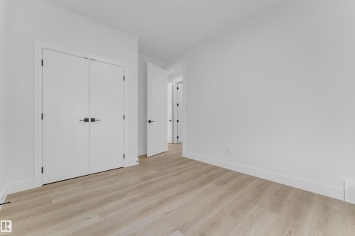 Spacious interior with light wood-finish flooring - 449 Crystal Creek Link, Leduc, AB - Indoor Photo Showing Other Room