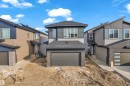 Contemporary two-story residence featuring a dark gray garage door, light gray siding, and a prominent front-facing window grouping - 449 Crystal Creek Link, Leduc, AB  - Outdoor 
