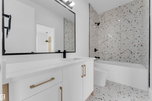 Bathroom featuring a white vanity with gold-tone hardware, a rectangular undermount sink, and a matte black faucet - 449 Crystal Creek Link, Leduc, AB - Indoor Photo Showing Bathroom