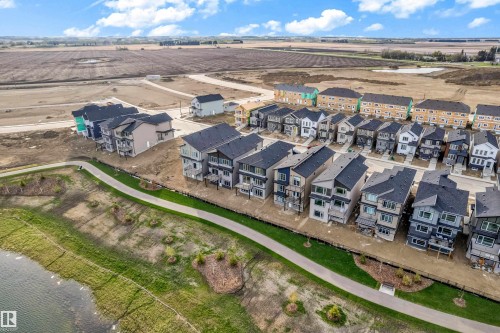 Aerial perspective showcasing numerous multi-story residential properties with varied exterior finishes - 449 Crystal Creek Link, Leduc, AB - Outdoor With View