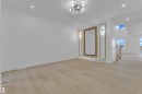 Spacious room featuring wood-finish flooring, recessed lighting, and a contemporary ceiling fixture - 449 Crystal Creek Link, Leduc, AB  - Indoor Photo Showing Other Room 