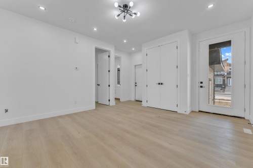Expansive room featuring wood-finish flooring, recessed lighting, and a modern ceiling fixture - 449 Crystal Creek Link, Leduc, AB - Indoor Photo Showing Other Room