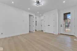 Expansive room featuring wood-finish flooring, recessed lighting, and a modern ceiling fixture - 