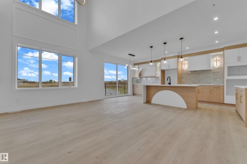 Expansive open-concept living space with high ceilings and wood-finish flooring - 449 Crystal Creek Link, Leduc, AB - Indoor Photo Showing Kitchen