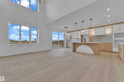 Expansive open-concept living space with high ceilings and wood-finish flooring - 