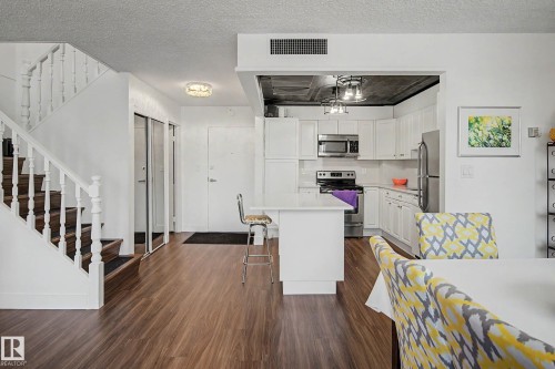Open-concept living space with wood-finish flooring throughout - 1205 10045 118 Street, Edmonton, AB - Indoor