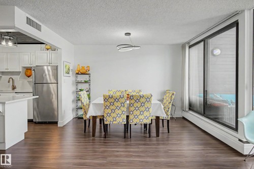 Open-concept living space featuring wood-finish flooring and a contemporary chandelier - 1205 10045 118 Street, Edmonton, AB - Indoor