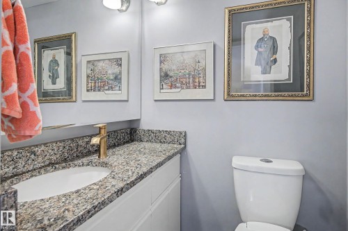 Bathroom vanity featuring a granite countertop, undermount sink, and a gold-finish single-handle faucet - 1205 10045 118 Street, Edmonton, AB - Indoor Photo Showing Bathroom
