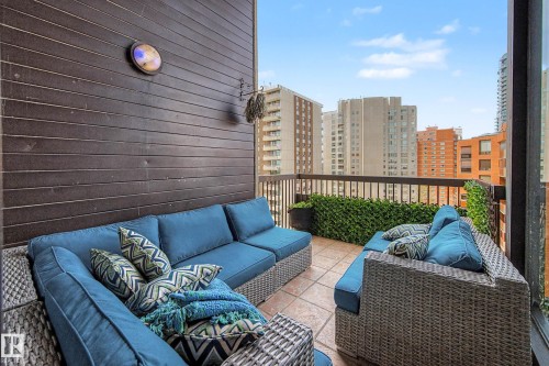 Private balcony with tile flooring, dark wood-paneled wall, and a metal railing - 1205 10045 118 Street, Edmonton, AB - Outdoor With Exterior