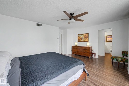 Spacious room with wood-finish flooring, a ceiling fan with integrated lighting, and a white color palette - 1205 10045 118 Street, Edmonton, AB - Indoor Photo Showing Bedroom