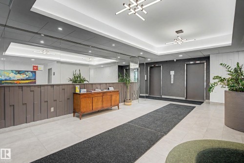 Lobby area featuring light-toned tile flooring and dark gray accent walls - 1205 10045 118 Street, Edmonton, AB - Indoor Photo Showing Other Room