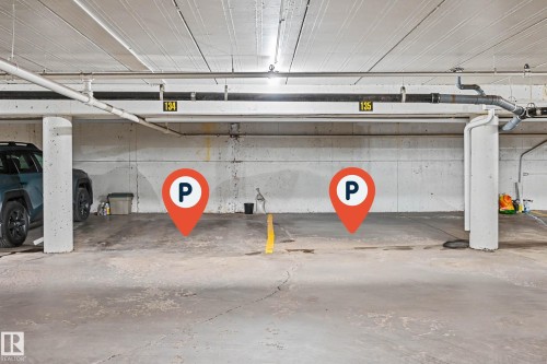 Underground parking space featuring concrete flooring, exposed ceiling utilities, and designated parking lines - 1205 10045 118 Street, Edmonton, AB - Indoor Photo Showing Garage