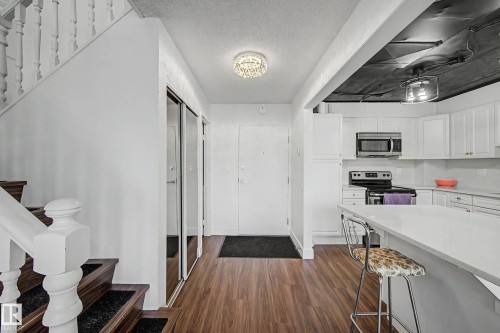 Entryway with wood-finish flooring and a crystal flush-mount light fixture - 1205 10045 118 Street, Edmonton, AB - Indoor Photo Showing Kitchen