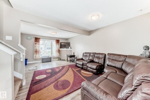 Spacious living area featuring light wood-finish flooring, neutral wall tones, and recessed ceiling lighting - 1 12833 123 Street, Edmonton, AB - Indoor Photo Showing Other Room