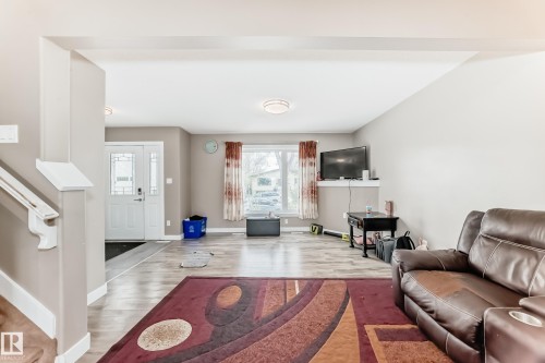 Open-concept living area featuring wood-finish flooring and neutral wall tones - 1 12833 123 Street, Edmonton, AB - Indoor Photo Showing Other Room