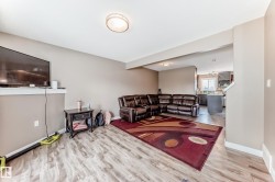 Spacious living area featuring wood-finish flooring, neutral wall paint, and recessed ceiling lighting - 