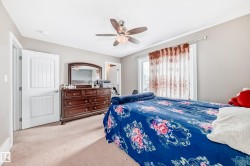 Carpeted room featuring a ceiling fan with light fixture, a window with decorative curtains, and a white paneled door - 