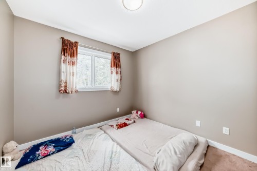 Room featuring neutral-toned walls, white trim, and carpet flooring - 1 12833 123 Street, Edmonton, AB - Indoor Photo Showing Bedroom