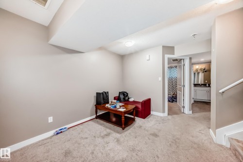 Carpeted room with neutral wall tones and white baseboards - 1 12833 123 Street, Edmonton, AB - Indoor Photo Showing Other Room