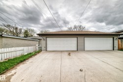 Detached garage featuring two overhead doors, horizontal siding, and a shingle roof - 