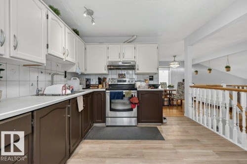 Kitchen featuring two-tone cabinetry, white countertops, and white square tile backsplash - 157 Kiniski Crescent, Edmonton, AB - Indoor Photo Showing Kitchen