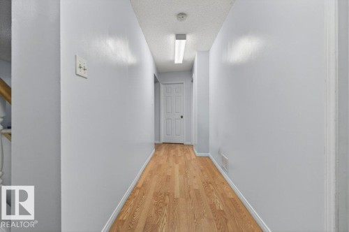 Hallway featuring wood-finish flooring, light gray wall paint, and overhead fluorescent lighting - 157 Kiniski Crescent, Edmonton, AB - Indoor Photo Showing Other Room