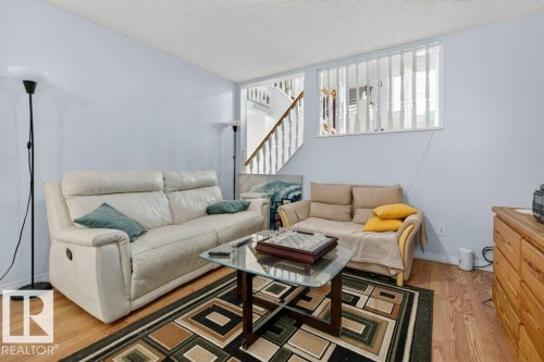 Living area featuring light blue walls and wood-finish flooring - 157 Kiniski Crescent, Edmonton, AB - Indoor Photo Showing Living Room