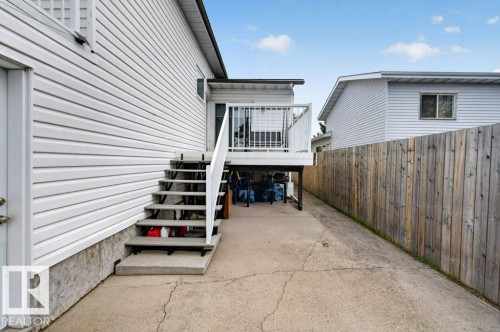Exterior featuring white horizontal siding, a concrete patio, a wood privacy fence, and a raised composite deck with white railings - 157 Kiniski Crescent, Edmonton, AB - Outdoor With Deck Patio Veranda With Exterior