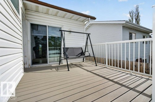 Spacious outdoor deck featuring composite decking, white railing, and sliding glass door access - 157 Kiniski Crescent, Edmonton, AB - Outdoor With Deck Patio Veranda With Exterior