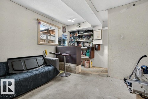 Concrete flooring with a built-in bar, open shelving, and a wood-framed window - 157 Kiniski Crescent, Edmonton, AB - Indoor