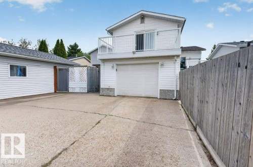 White-sided exterior with an attached garage and an upper-level balcony featuring white railings - 157 Kiniski Crescent, Edmonton, AB - Outdoor With Exterior