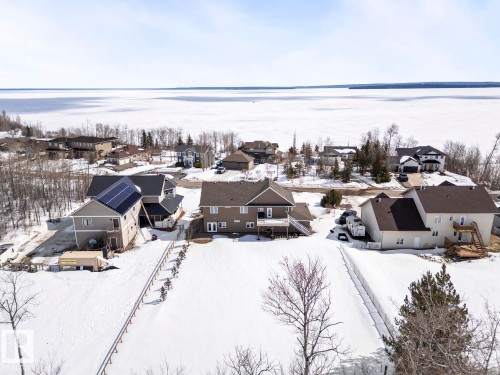 This property features a spacious lot with a fence, and includes a solar panel array on the roof - 1513 Horseshoe Bay Estates, Cold Lake, AB - Outdoor With Body Of Water With View