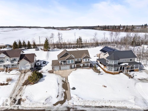 The property features a multi-story design with a prominent gable roof and an attached garage - 1513 Horseshoe Bay Estates, Cold Lake, AB - Outdoor With Body Of Water With View
