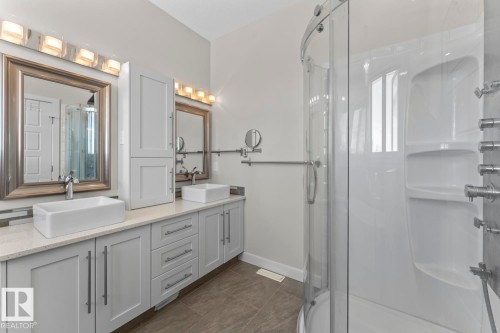 The bathroom features a double vanity with two vessel sinks, light-colored countertops, and ample cabinet storage - 1513 Horseshoe Bay Estates, Cold Lake, AB - Indoor Photo Showing Bathroom
