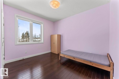 Room with hardwood floors, a window offering views of trees, and a ceiling light fixture - 1513 Horseshoe Bay Estates, Cold Lake, AB - Indoor Photo Showing Other Room