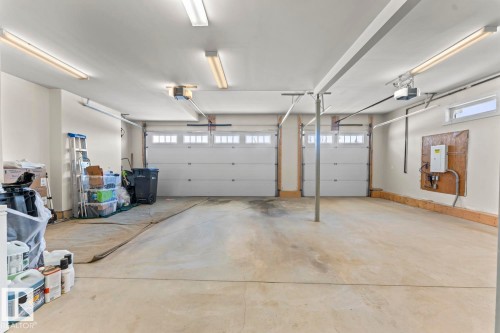 Spacious garage featuring two overhead doors, a concrete floor, and ample overhead lighting - 1513 Horseshoe Bay Estates, Cold Lake, AB - Indoor Photo Showing Garage
