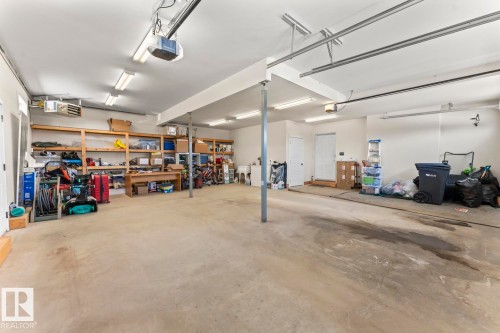 Spacious garage featuring concrete flooring, track lighting, and built-in shelving for storage - 1513 Horseshoe Bay Estates, Cold Lake, AB - Indoor Photo Showing Garage
